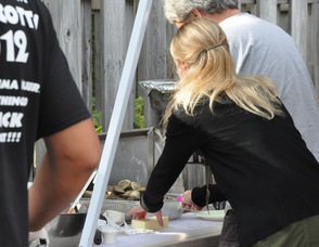 A volunteer prepares butter to accompany the clams.