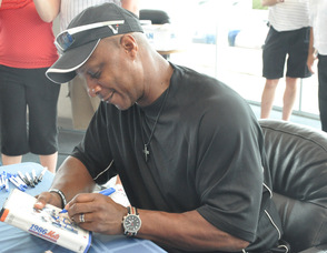 Strawberry signs an item for a fan.