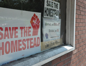 Signs asking to "Save The Homestead" in a window along Spring Street in Newton. 