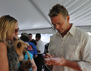 John Schneider signs an item for a fan, and her dog.