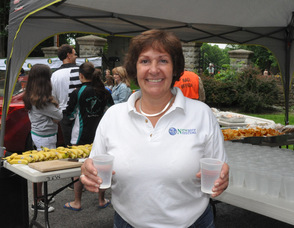 Elisa DeYoung of Newater Systems read to hand out waters to runners at the finish line.