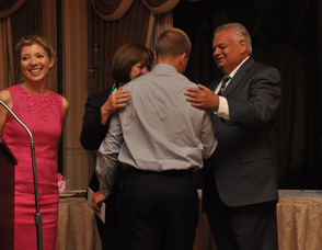 Evan Towle is congratulated by Ann and Richard Pompelio after receiving the Tony Pompelio & Schoolmates Award of Courage, as Jennifer Jean Miller of TheAlternativePress.com, the presenter, looks on.