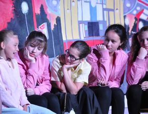 The girls of Rydell High surround Sandy to hear her story.