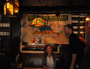 One of the waiters at Krogh's takes a customer's order, as she sits underneath a HOW Global banner.