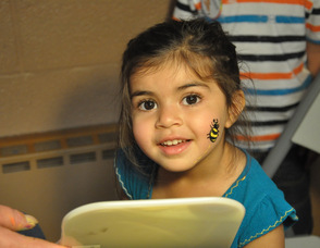 Juliette Matti, age 3, admires the bumble bee painted on her face.