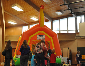 Children excitedly wait to enter the dinosaur bounce house.