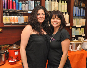 Jana Robertson, and Kathy Czerhoniak of Salon Di Panache, stand in front of the chilis for their cook off to benefit O.S.C.A.R.