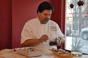 Chef George Mandakas of Innova Cuisine, prepares oysters on the half shell with pomegranate and pink peppercorn pearls.