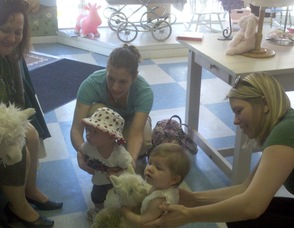 Children gather around author Deborah Guarino at Mother Moon Baby Boutique.