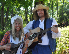 Local musicians Deb D'Anne and Mingo Lodge strum their guitars while in period-style costume.