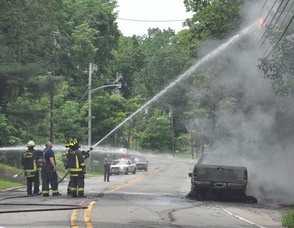 Members of the Newton Fire Department work to extinguish flaming utility wires.