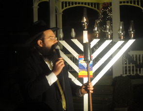 Rabbi Shalom Lubin, the director of the Chabad Jewish Center of Madison lighting the menorah