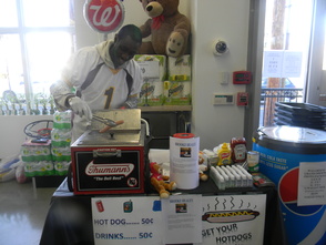 An employee serving hot dogs