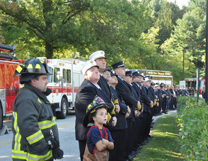 Firefighters look up to the New Jersey State Police Flyover.