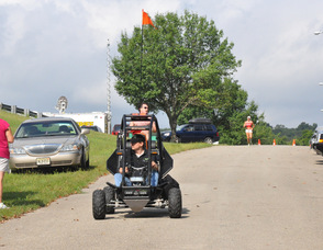 Samuel Burlum leads the race in a Sidewinder ATV with Brian Thomas, and Catherine Stone, running behind. 