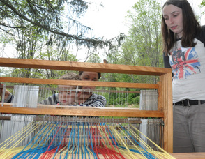 Elizabeth Dwyer, age 16, of Branchville, guides Liz Dwyer of Hardwick, and son Sid, on operating a loom.