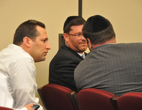 Bidders for Sentosa Care LLC, and Altitude Health Services, Inc. hold a discussion among themselves before the first winning bid was announced.