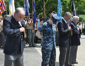 Past and present members of the military stand at attention.