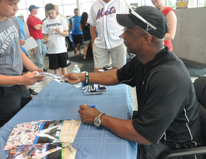 Darryl Strawberry signs a photo for a young fan.