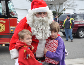 Santa steals a hug from brother Damon, and Ronan Postance, ages 10, and 7.