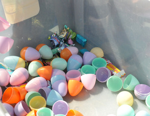 Children toss their eggs back into the bin in Newton, with some pieces of candy making its way in as well.