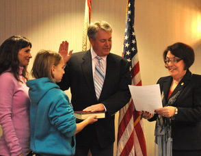 Samantha Lensak holds the Bible for her father Michael Lensak, as he is sworn in by administrator/clerk Vita Thompson, for another term as committee member. Wife Lisa is also pictured. Lensak was sworn in twice during the evening, also for deputy mayor.
