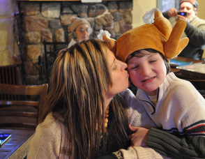 Erica Alcock-Phillips plants a kiss on the cheek of son, Lennon Alcock, age 8, who sported a turkey hat.