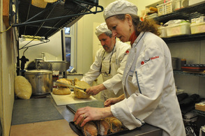 Bobolink Dairy owners and chefs Nina and Jonathan White slice freshly baked bread with garlic.