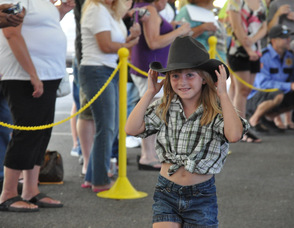 A "Little Miss Daisy Duke" holds onto her hat.