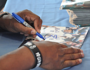 Strawberry signing a photo.