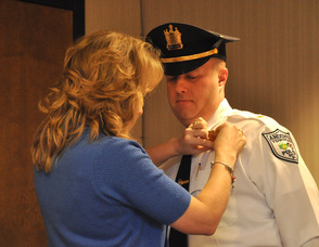 Debbie Danielson pins on the lieutenant's badge for her husband, Eric Danielson, newly sworn in Andover Township Police Lieutenant.