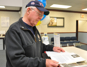 Thomas Cooney looks through his book of tributes, remembrances, and articles about his 9/11 display.