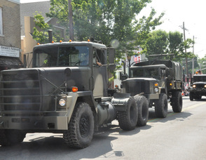 Military vehicles proceed down Spring Street.