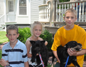 Mikey Toepher, age 10, and siblings Emily, age 8, and Charlie, 12, hold dogs Disney and Tony, available for adoption through O.S.C.A.R. at Salon Di Panache.