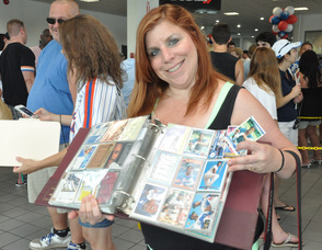 Dawn Schriever holds up a book filled with baseball cards.