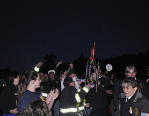 Franklin Fire Department cheering wildly as they hold up their trophy.