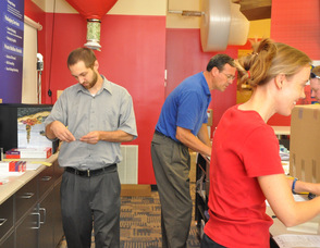 Steve Geary, Dan Thomas, and Wendy Asplund handling various facets of the business from behind the counter.