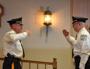 Andover Township Police Chief Gil Taglialatela (left), and Lieutenant Eric Danielson (right) salute each other in unison, after Danielson has taken his oath.