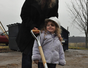 Three-year-old Brianna Strada sports a hard hat and poses with a shovel at the groundbreaking site, along with her mother, Kim.