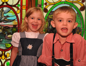 Twins Erika and Daniel Koster, age 4, smile for the camera by one of the restaurant's stained glass windows.