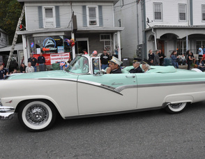 Sussex Fire Department dignitaries ride in a classic car.