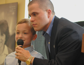 Matthew Guziewicz speaks into the microphone as Thomas S. Russo, Jr. looks on.