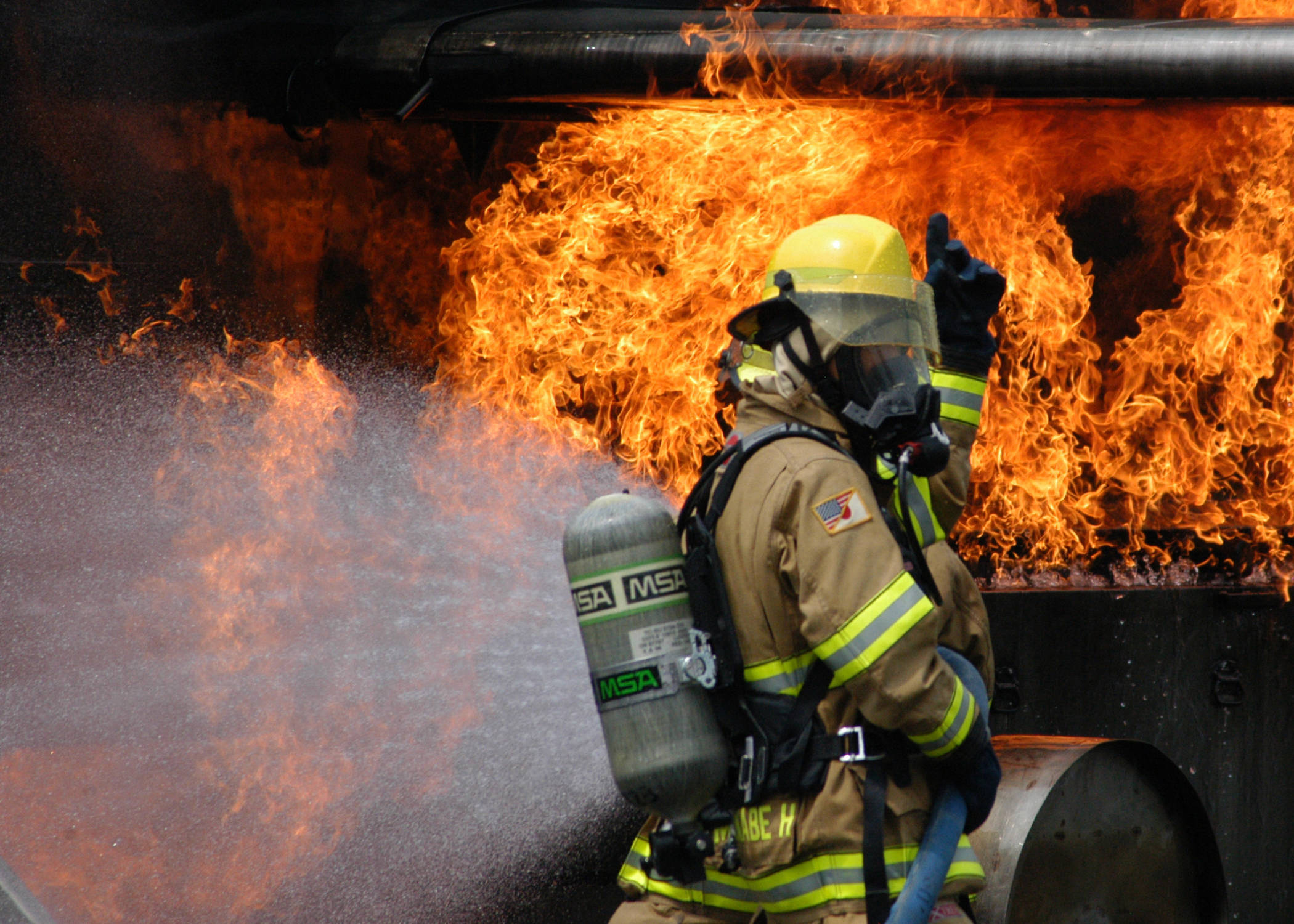 3ce61b77bac14c249bb4_US_Navy_080730-N-5277R-004_A_firefighter_assigned_to_Naval_Air_Facility_Atsugi_douses_out_a_live_fire_on_a_dummy_aircraft.jpg