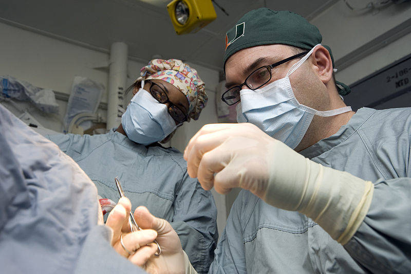 9a7ccb349f14fb7ff949_800px-US_Navy_120120-N-JN664-004_Lt._Cmdr._Howard_Pryor__a_Navy_doctor__stitches_an_incision_while_Hospital_Corpsman_3rd_Class_Destiny_Dansby_observes_in.jpg