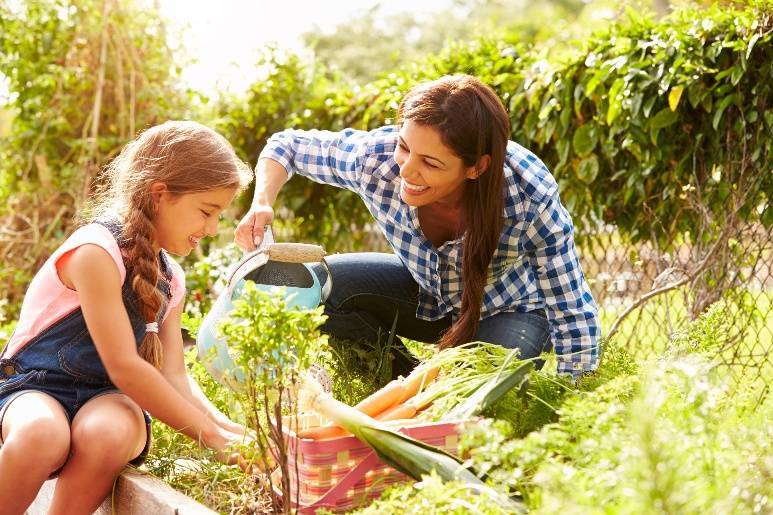9c687e8b6db34c903f4a_Mom-Daugher_Watering_Garden.jpg
