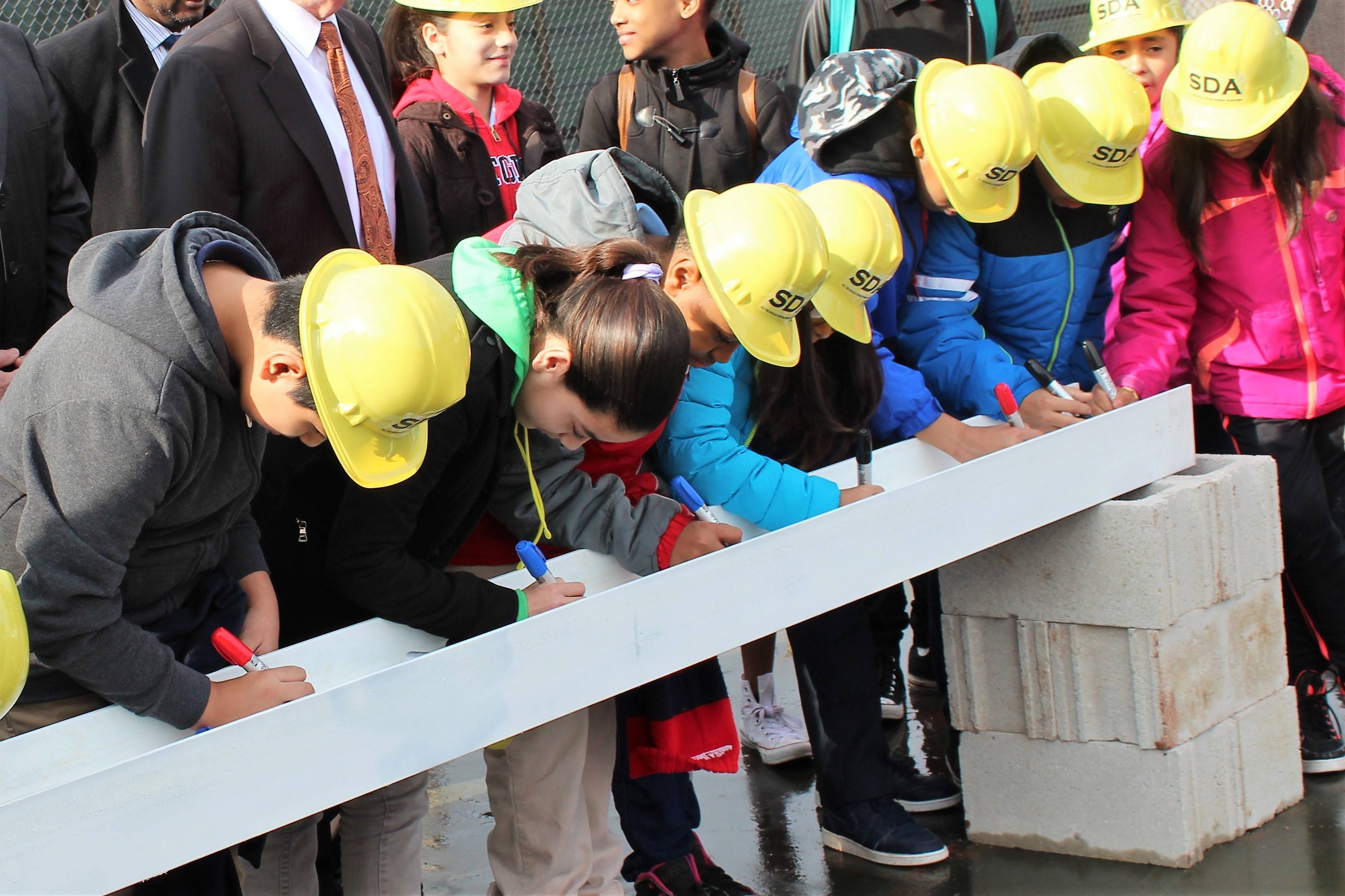 c1c63497aa556aa05bf1_New_Brunswick_Students_Sign_a_Piece_of_Steel.jpg